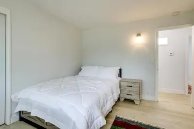 a bedroom with a white bed and a wooden floor at 4 Mi to Folsom Lake Modern Home with Patio! in Granite Bay