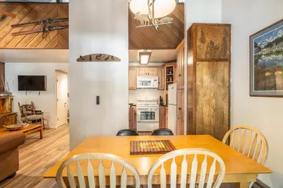 a dining room and kitchen with a wooden table and chairs at Sunshine Village 120 in Mammoth Lakes