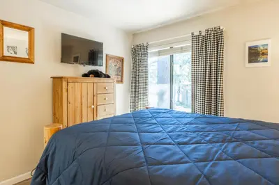 a bedroom with a blue bed and a window at Sunshine Village 120 in Mammoth Lakes