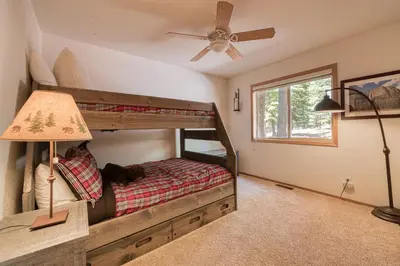 a bedroom with a bunk bed and a ceiling fan at Jackpine Lodge at Tahoe Donner by Tahoe Getaways - Private Hot Tub w Foosball and HOA in Truckee