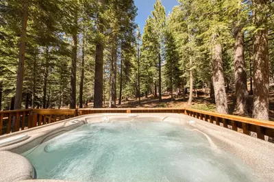 a hot tub in the middle of a forest at Jackpine Lodge at Tahoe Donner by Tahoe Getaways - Private Hot Tub w Foosball and HOA in Truckee