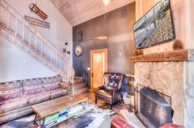 a living room with a fireplace and a staircase at Relax at Rustic Tahoe Charm - Minutes to Lake in Tahoma