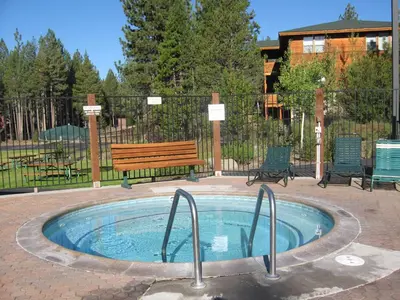 a hot tub in a patio with a bench at Serenity at Tahoe Donner with Large Balcony in Truckee