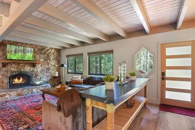 a living room with a table and a fireplace at Serenity on Statford - Close to Northstar in Tahoe Vista