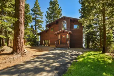 a large wooden house in the middle of a forest at Shoreline Vista - Lake Views Near Hike & Bike in Carnelian Bay