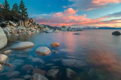 a rocky shore with rocks in the water at sunset at Silver Tree Sanctuary in Aspen Grove in Truckee