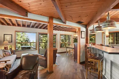 a kitchen and living room with wood ceilings and windows at Snowshoe Cabin - 3 Decks BBQ & Hot Tub in Tahoe City