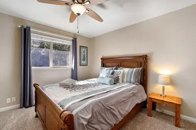 a bedroom with a bed and a ceiling fan at Tahoe Frost - Air conditioned 4 bedroom Tahoe home in South Lake Tahoe