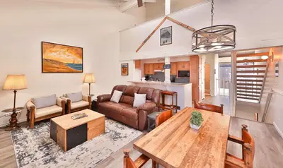 a living room with a table and a couch at Tahoe Lakeside Retreat - Lakefront Condo in South Lake Tahoe