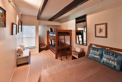 a room with a bed and a bunk bed with a couch at Tahoe Lakeside Retreat - Lakefront Condo in South Lake Tahoe
