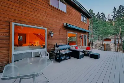 a wooden deck with a large window and furniture on it at The Elevator House - Sleeps 10 in Stateline