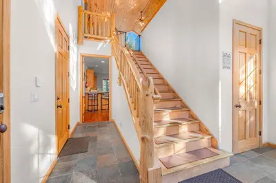 a staircase in a living room with white walls at The Lodge on Oaxaco - Epic Man Cave with Billiard Room in South Lake Tahoe