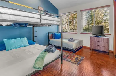 a bedroom with two bunk beds and a flat screen tv at The Lodge on Oaxaco - Epic Man Cave with Billiard Room in South Lake Tahoe