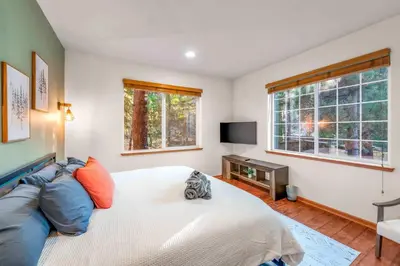 a bedroom with a bed and a tv and windows at The Lodge on Oaxaco - Epic Man Cave with Billiard Room in South Lake Tahoe