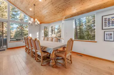 a dining room with a table and chairs and windows at The Lodge on Oaxaco - Epic Man Cave with Billiard Room in South Lake Tahoe