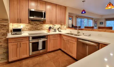 a kitchen with wooden cabinets and stainless steel appliances at The Meadows - Ski Lease - Extended 30 Plus Days in South Lake Tahoe