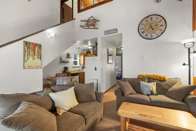 a living room with a couch and a clock on the wall at Valley View - Carson Valley Views in Stateline