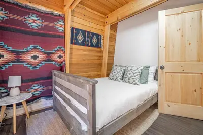 a bedroom with a bed in a wooden cabin at Canoe Cabin I Sleeps 8 I Hot Tub I Pet Friendly in Incline Village