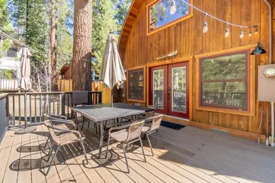 a wooden deck with a table and chairs on a cabin at Canoe Cabin I Sleeps 8 I Hot Tub I Pet Friendly in Incline Village