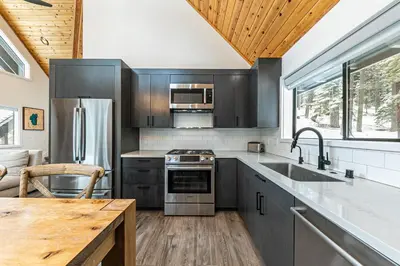 a kitchen with stainless steel appliances and a wooden ceiling at Misty Pines by Tahoe Getaways at Tahoe Park - Newly Remodeled Pet Friendly 3 BR w Private Beach HOA in Tahoe City
