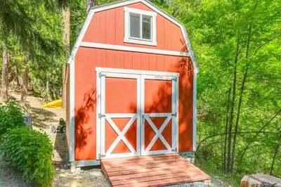 a red barn with a door and a porch at Peaceful Forest Views and Patio Twain Harte Home in Twain Harte
