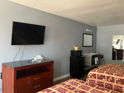 a hotel room with a bed and a tv on the wall at Oasis Inn and Suites in Fallon
