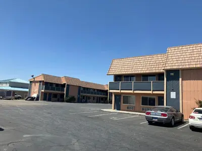 a parking lot with cars parked in front of a building at Oasis Inn and Suites in Fallon