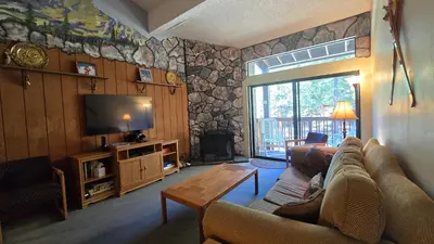a living room with a couch and a tv at Eagle Summit Collection in Mammoth Lakes