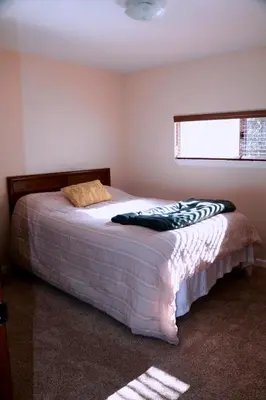 a bedroom with a bed in a room with a window at Bear Meadow Cabin at Shaver Lake in Shaver Lake