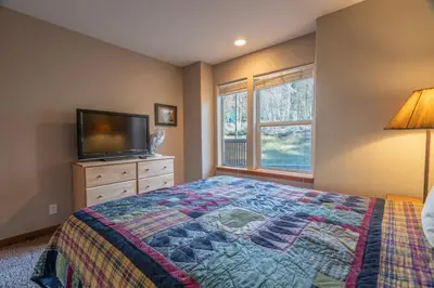 a bedroom with a bed and a flat screen tv at RR-Hideaway_Down_Cyn 105 in June Lake