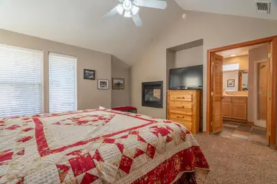 a bedroom with a bed and a flat screen tv at RR-Hideaway_Down_Cyn 105 in June Lake