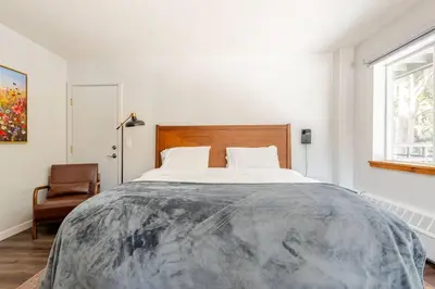 a bedroom with a large bed and a chair at The Lookout Loft Great views and King Sized Bed in Kirkwood