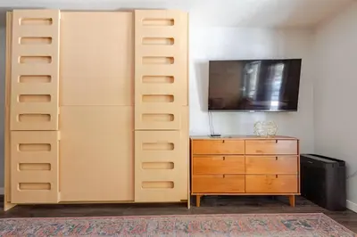 a closet with a dresser and a tv on a wall at Super-Efficient Studio with Full Kitchen Balcony & Smart Sleeping Options in Kirkwood