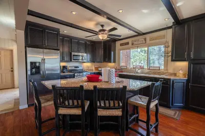 a kitchen with a large island with bar chairs at RR-Villa Lago STR AP 18-003 in June Lake