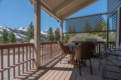 a deck with a table and chairs and mountains at RR-Villa Lago STR AP 18-003 in June Lake