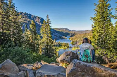 a woman sitting on a rock overlooking a lake at Mammoth Point 119 in Mammoth Lakes