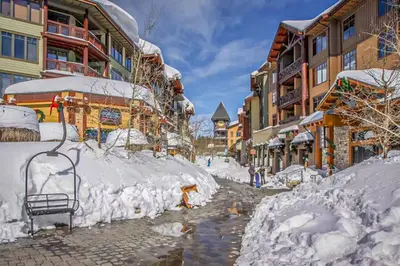 a street covered in snow next to buildings at Mammoth Point 119 in Mammoth Lakes