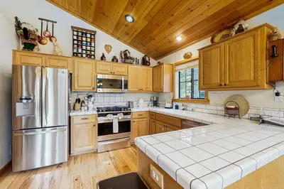 a kitchen with wooden cabinets and a stainless steel refrigerator at Chill on the Hill in Truckee