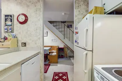 a kitchen with a white refrigerator and a staircase at Woodstock and Snoopy in Incline Village