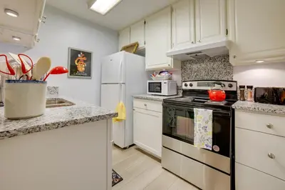 a kitchen with white cabinets and a stove top oven at 1 Mi to Reno-Sparks Family Retreat with Fireplace! in Reno
