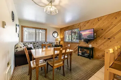 a dining room and living room with a table and a couch at 117 Bldg B condo in Truckee