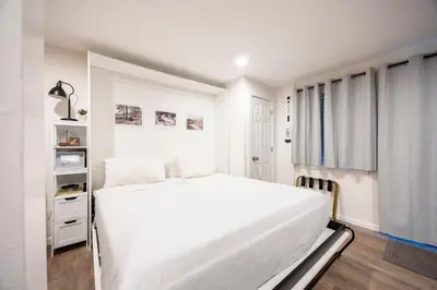 a white bedroom with a white bed and a window at 124 Bldg B studio in Truckee