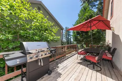a grill and a picnic table on a deck with an umbrella at Inside Yosemite Mountain Beauty in Yosemite West
