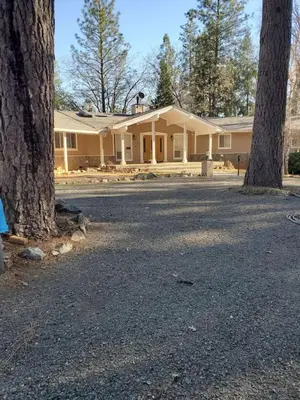 a large house with trees in front of it at Grass Valley Oasis - Spacious Family Retreat Near Rollins Lake in Grass Valley