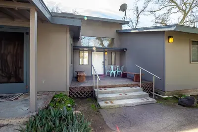 a house with a porch with a table on it at Grand Riverside Retreat - Private Walkway to the River in Three Rivers