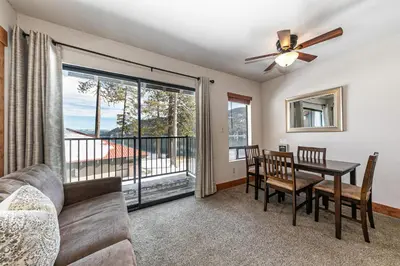 a living room with a couch and a dining room table with a window at 243 Bldg C condo in Truckee