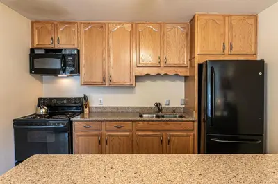 a kitchen with wooden cabinets and a black refrigerator at 222 Bldg B condo in Truckee