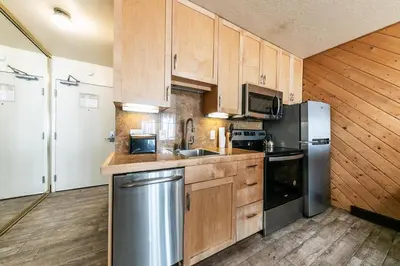 a kitchen with wooden cabinets and a stainless steel refrigerator at 122 Bldg B studio in Truckee