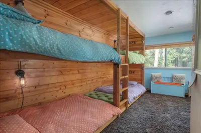 two bunk beds in a room with wooden walls at Cozy Cabin - Hot Tub, Fire Pit, & Pets in Arnold