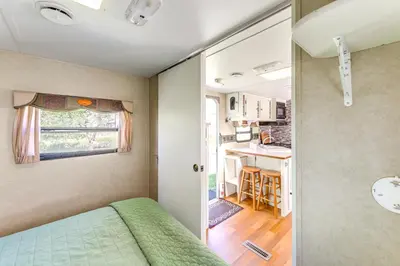 a small bedroom with a green bed and a kitchen at 11 Mi to Heavenly Mtn Resort Getaway with Mtn Views in Gardnerville